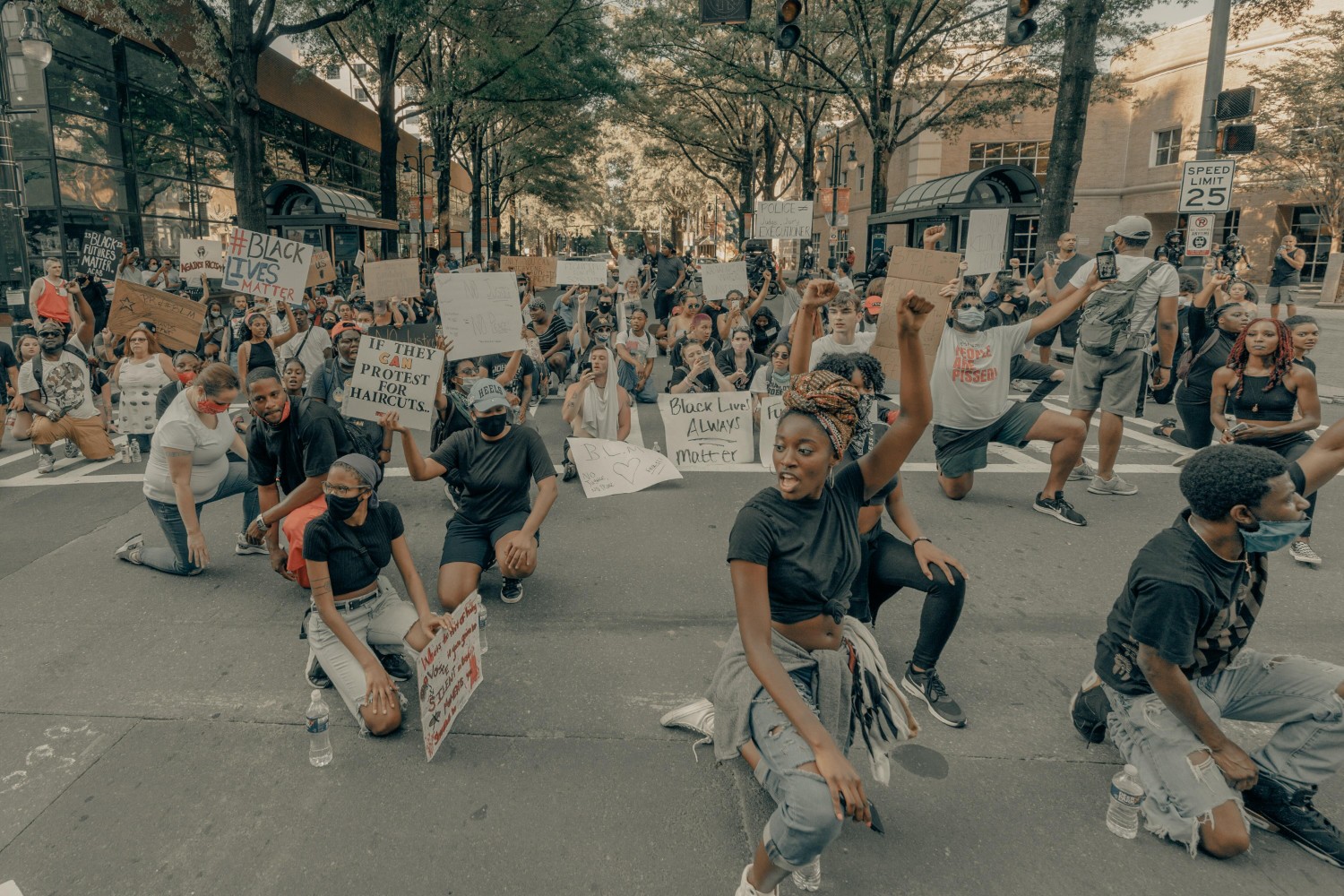 peaceful black protestors kneeling in the street photo by Clay Banks from Unsplash