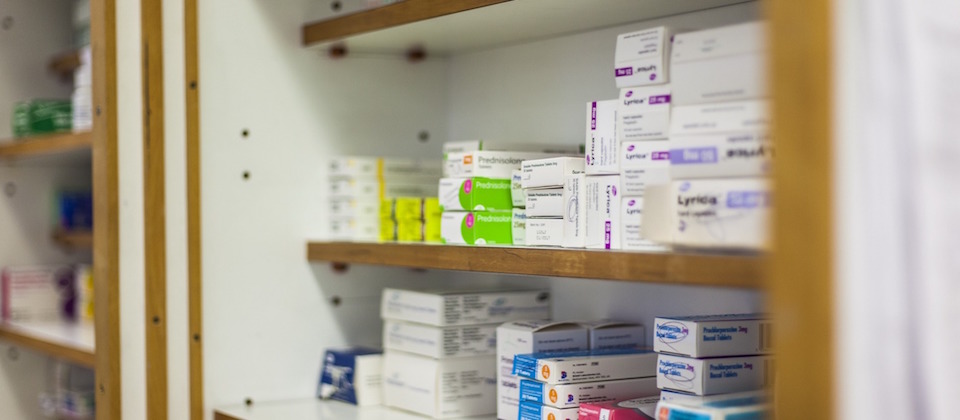 Photo of pharmacy shelves stocked with boxes of medication