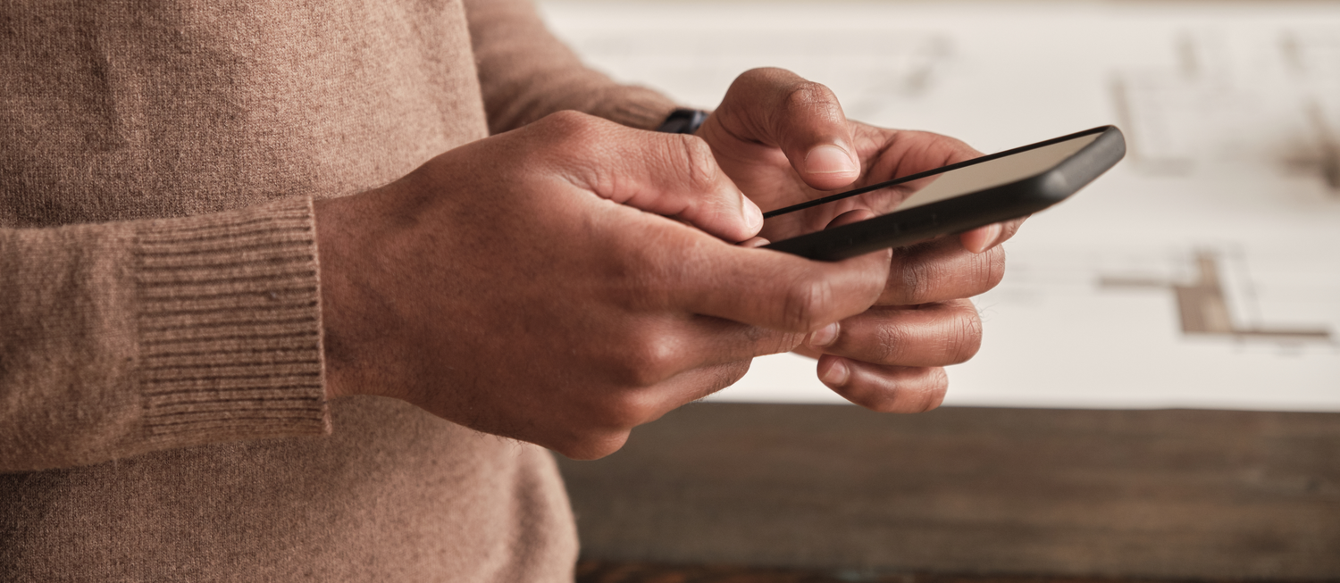 Close-up photo of a person's hands holding a cell phone.