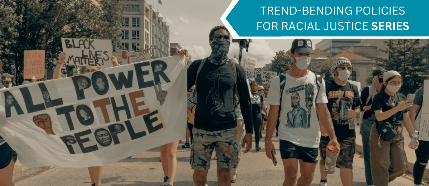 Photo of black lives matter protesters walking down a street. A blue banner in the top right corner reads 