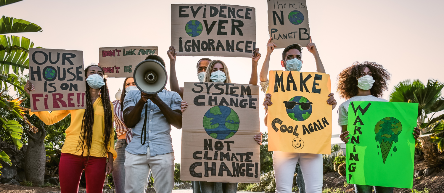 Photo of a group of people at a climate action protest with signs that say 