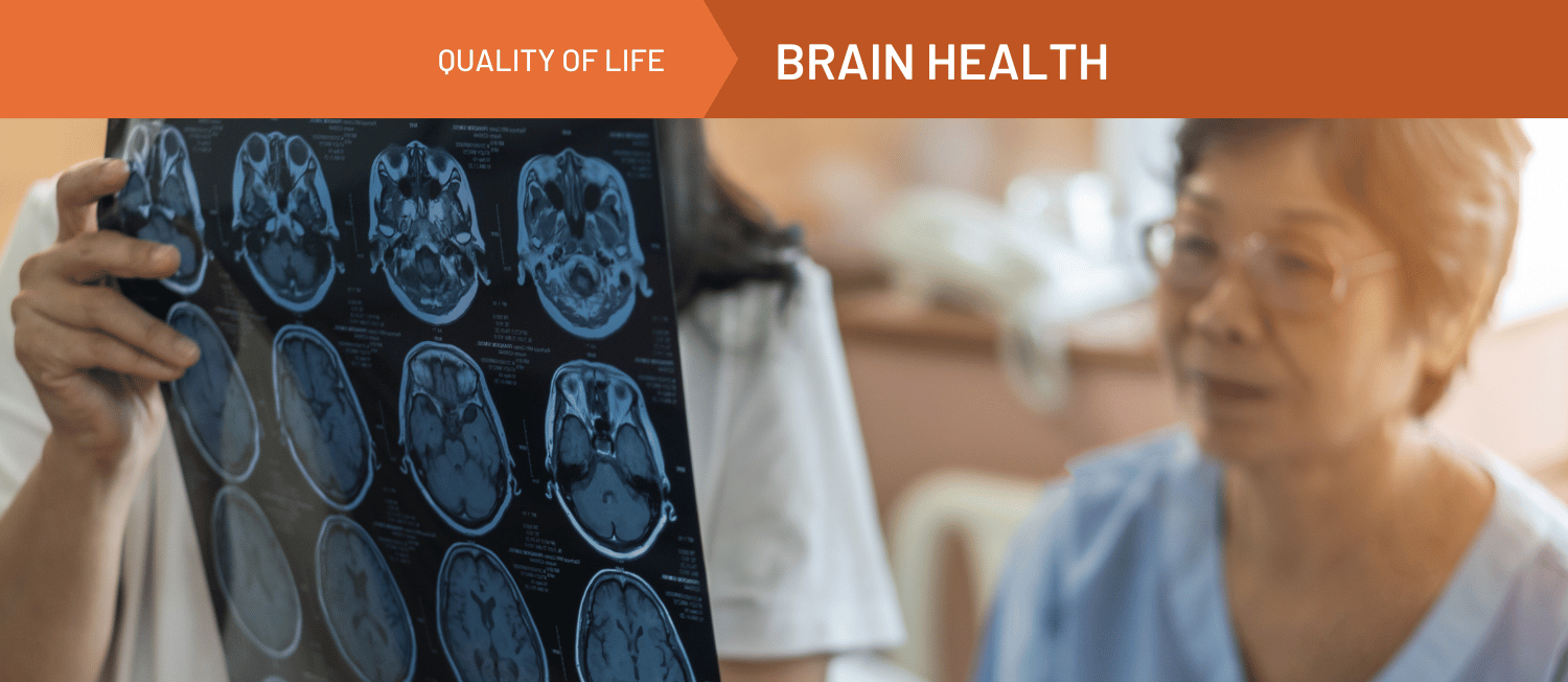 Photo of two medical professionals examining images from a brain scan. An orange banner spanning the top of the image reads 